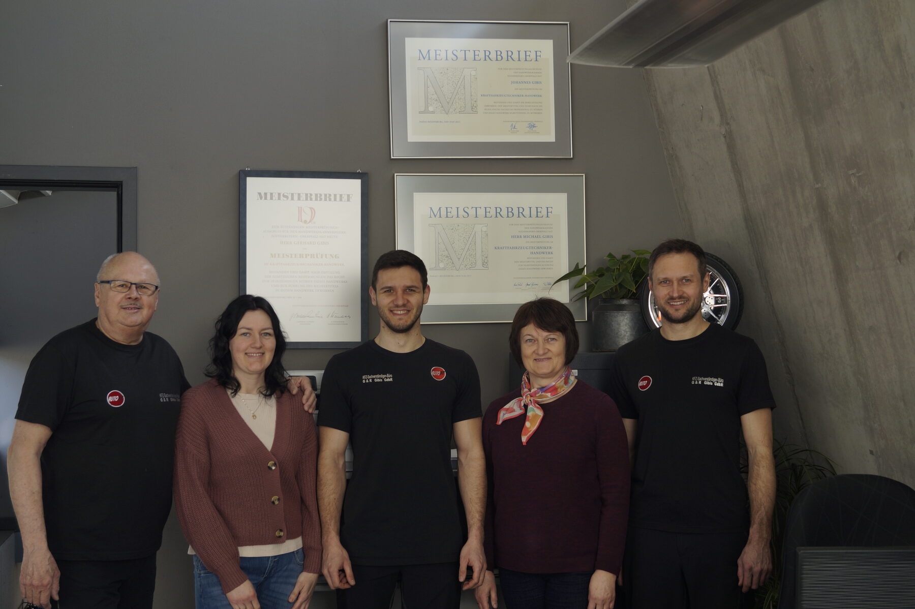 Team von Auto Gibis vor Meisterbriefen
